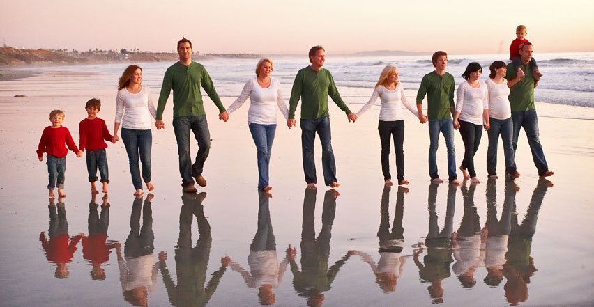 Location photography of large family walking holding hands on the beach in Oceanside California

