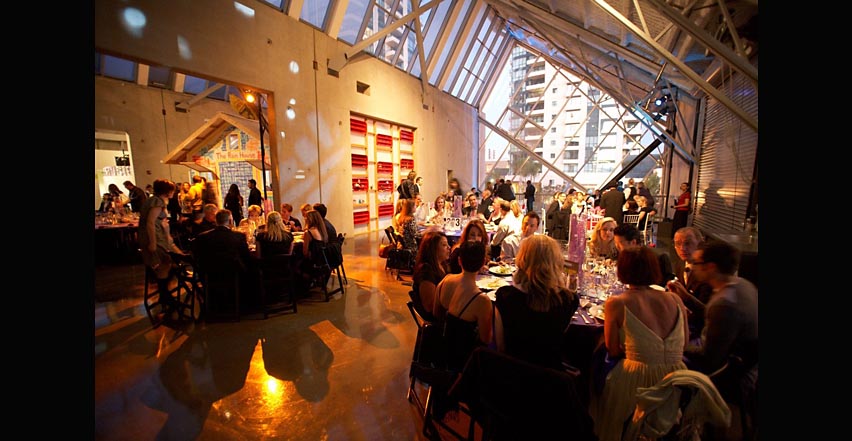 Event photography showing patrons eating under large glass roof at charity event  in San Diego California