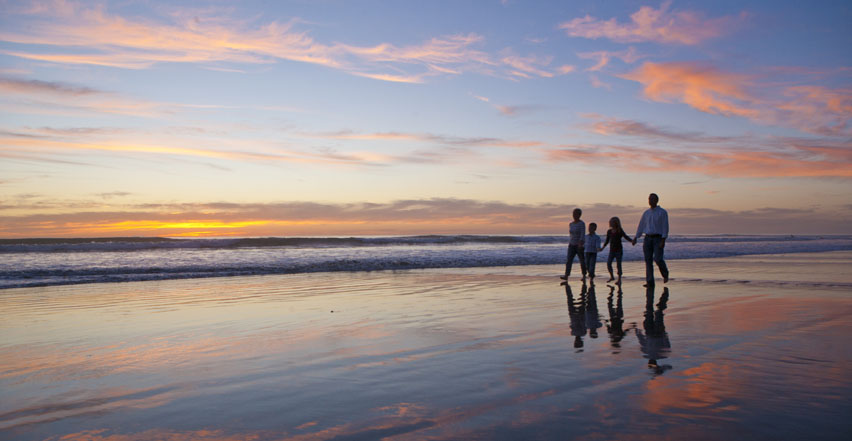 Location photography of large family walking holding hands on the beach in Oceanside California

